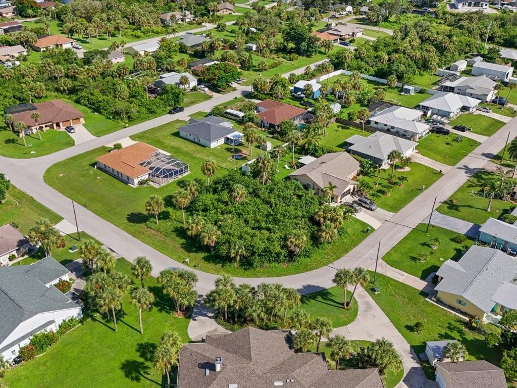 An aerial view of a suburban neighborhood with single-family homes, paved streets, and lush landscaping — 18443 BRIGGS CIRCLE, PORT CHARLOTTE, FL