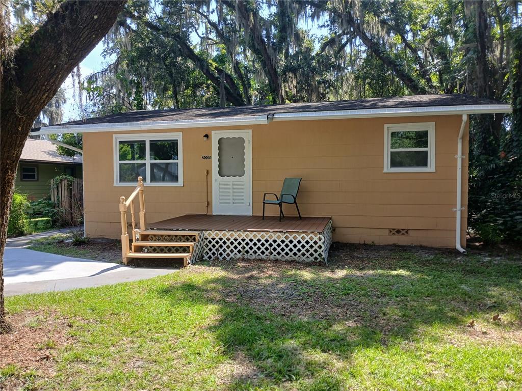 A tan, single-story house features a wooden deck, a white front door, and lattice skirting — 2005 JEFFERSON AVENUE, SANFORD, FL
