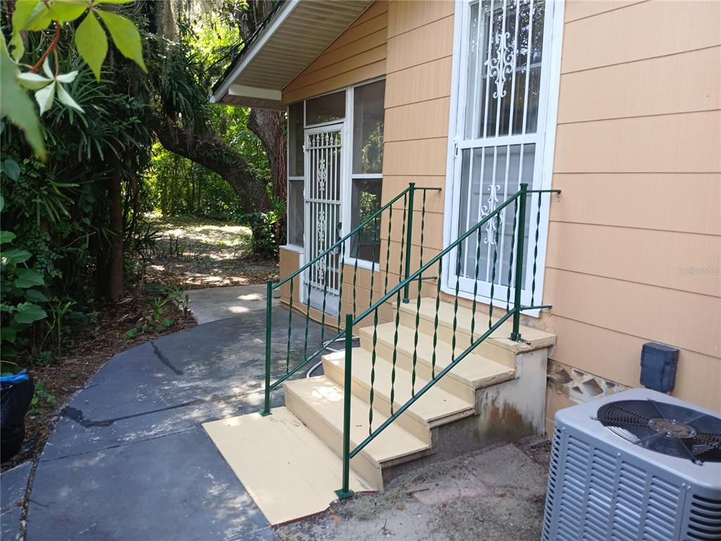 An exterior view shows a house with beige siding, a screened porch, and metal stairs — 2005 JEFFERSON AVENUE, SANFORD, FL