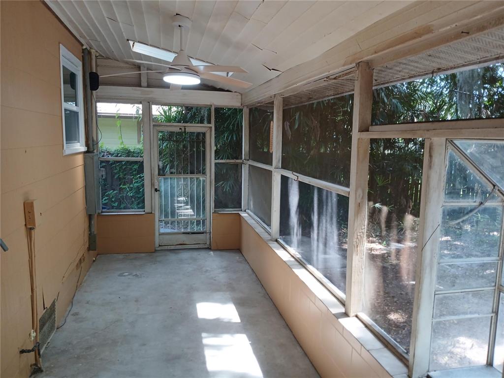 A screened-in porch with a concrete floor, ceiling fan, and views of the backyard — 2005 JEFFERSON AVENUE, SANFORD, FL