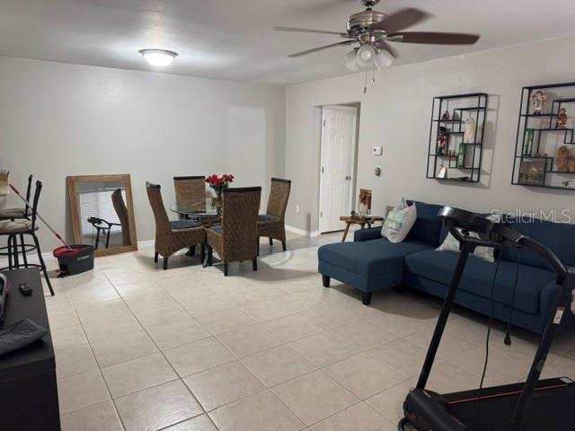 A living and dining area features tile flooring, a blue sectional sofa, and wicker chairs — 8472 60TH STREET N, PINELLAS PARK, FL