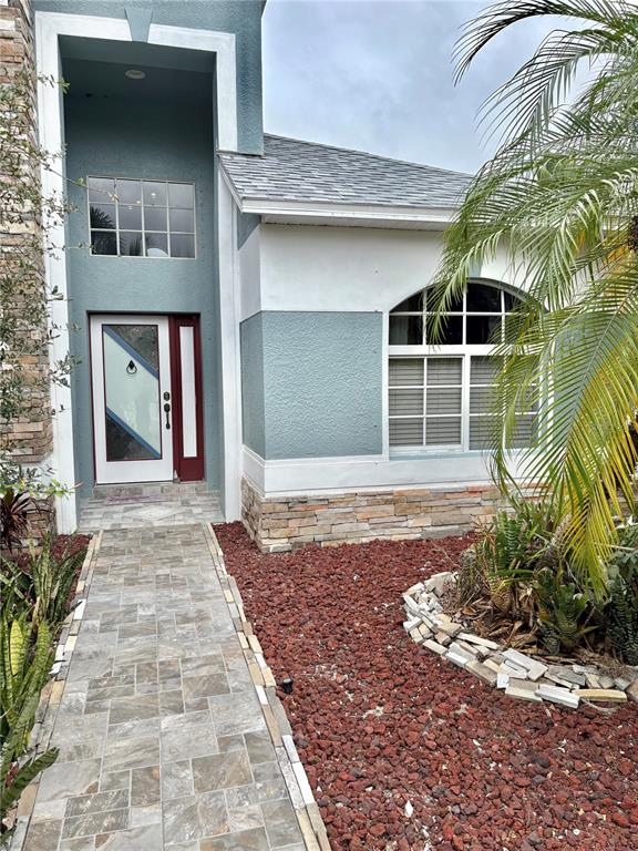 The exterior of a house features a tiled walkway, stone accents, and a front door — 6346 BOBBY JONES COURT, PALMETTO, FL