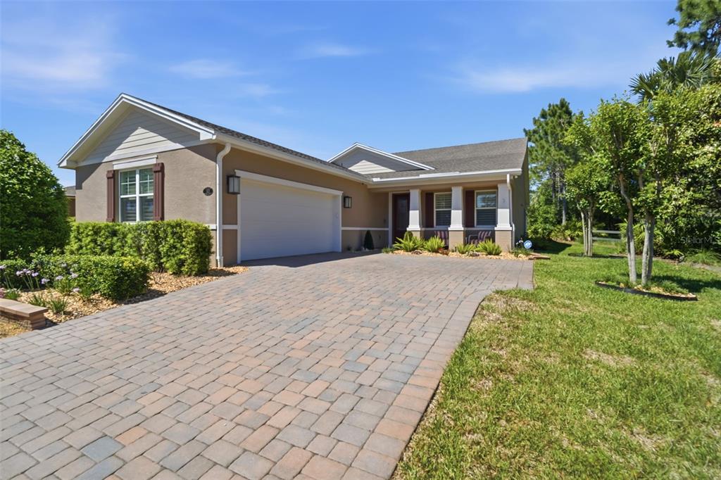 A single-story house with a paved driveway, a two-car garage, and a covered front porch — 103 OLD MOSS CIRCLE, DELAND, FL