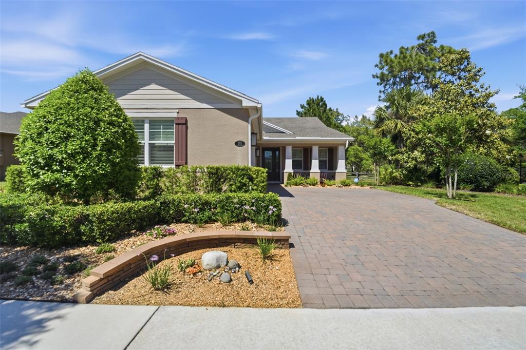 A single-story house with a paved driveway, landscaped front yard, and a curved retaining wall — 103 OLD MOSS CIRCLE, DELAND, FL