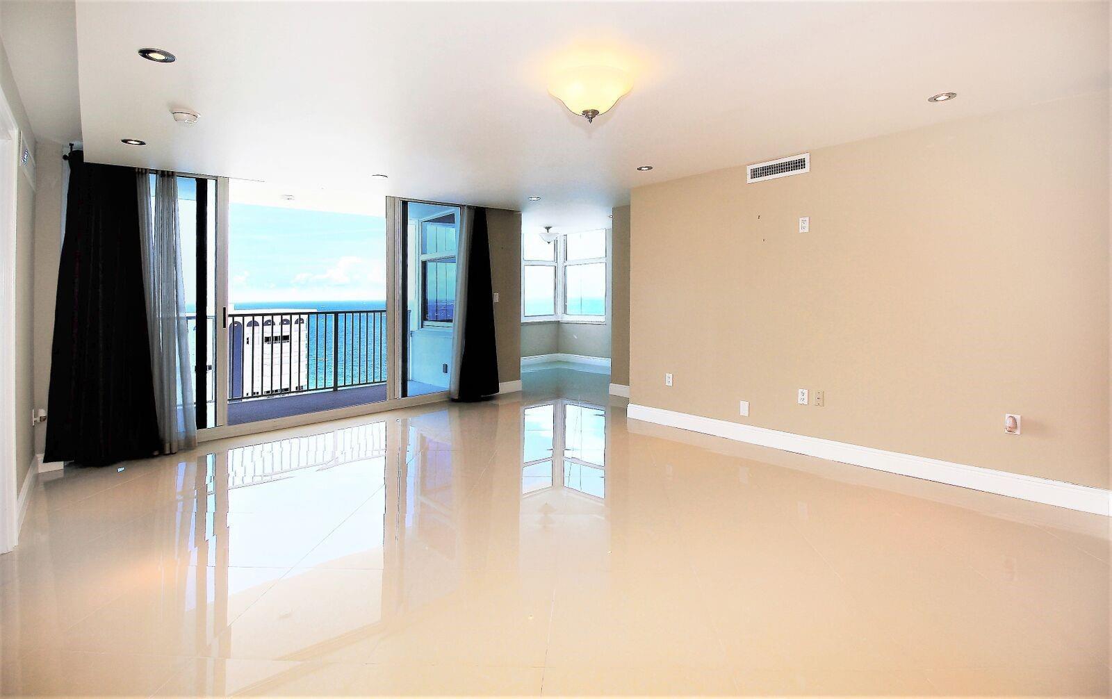 An empty living room with light tile floors, recessed lighting, and a balcony overlooking water — 1360 S Ocean Boulevard # 2806, Pompano Beach FL 33062, POMPANO BEACH, FL