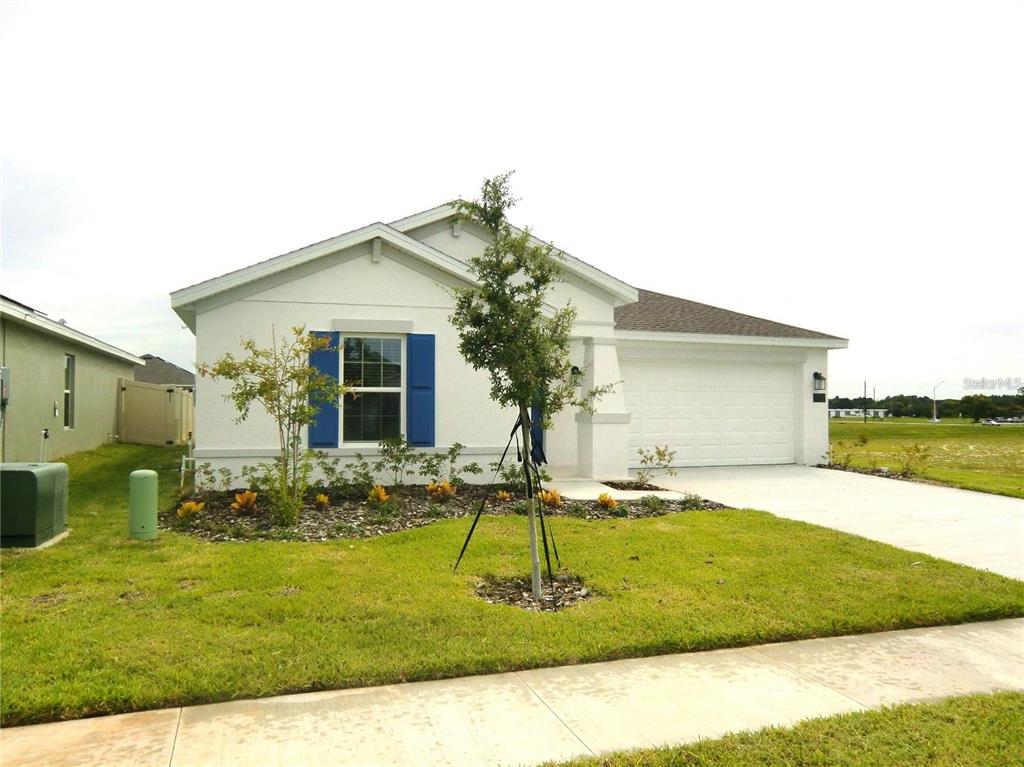 A single-story white house with blue shutters and a two-car garage — 172 INMAN BOULEVARD, WINTER HAVEN, FL