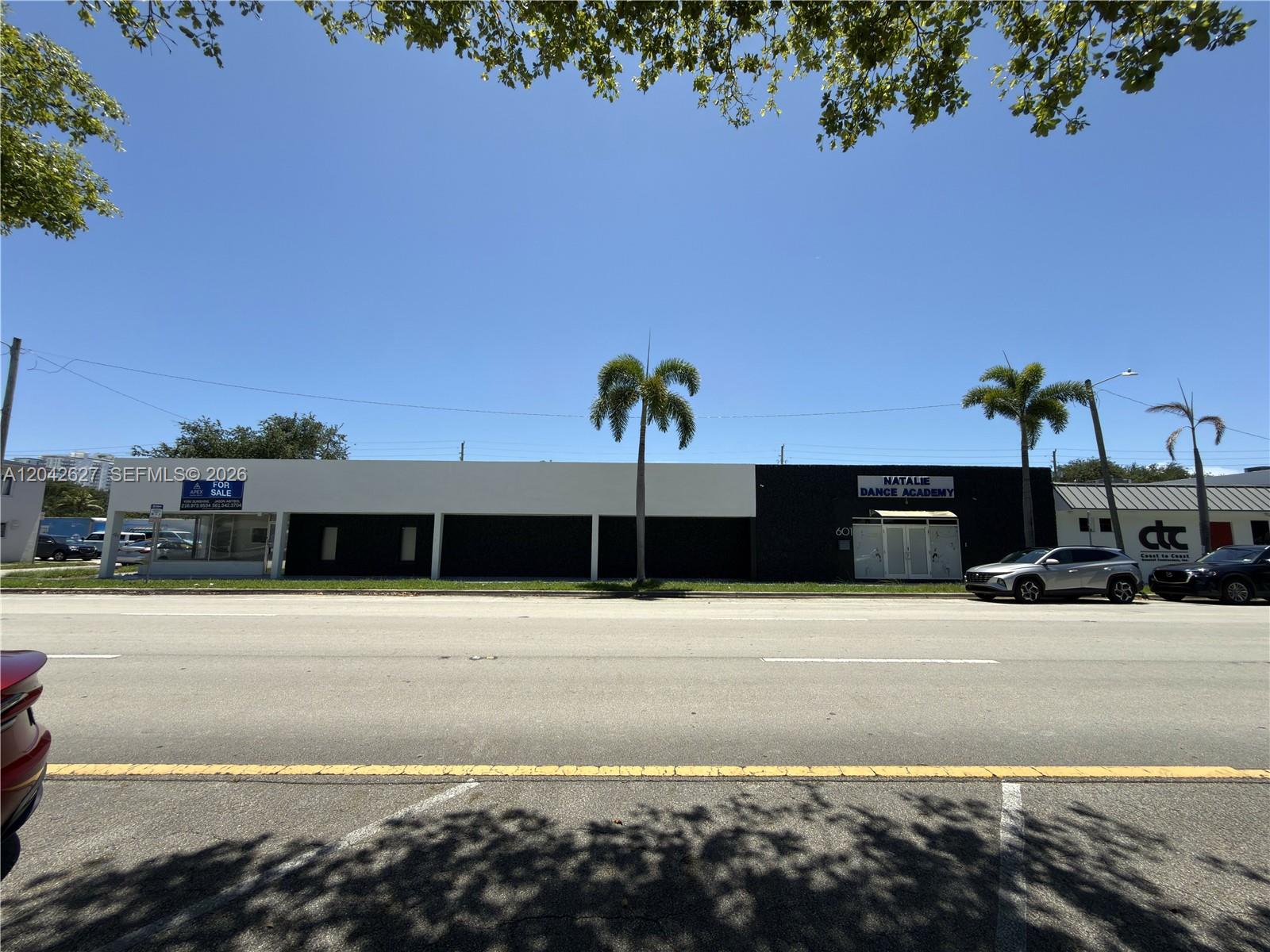 A single-story commercial building with a black and white facade sits along a road — 601 N 21st Ave, Hollywood FL 33020, HOLLYWOOD, FL