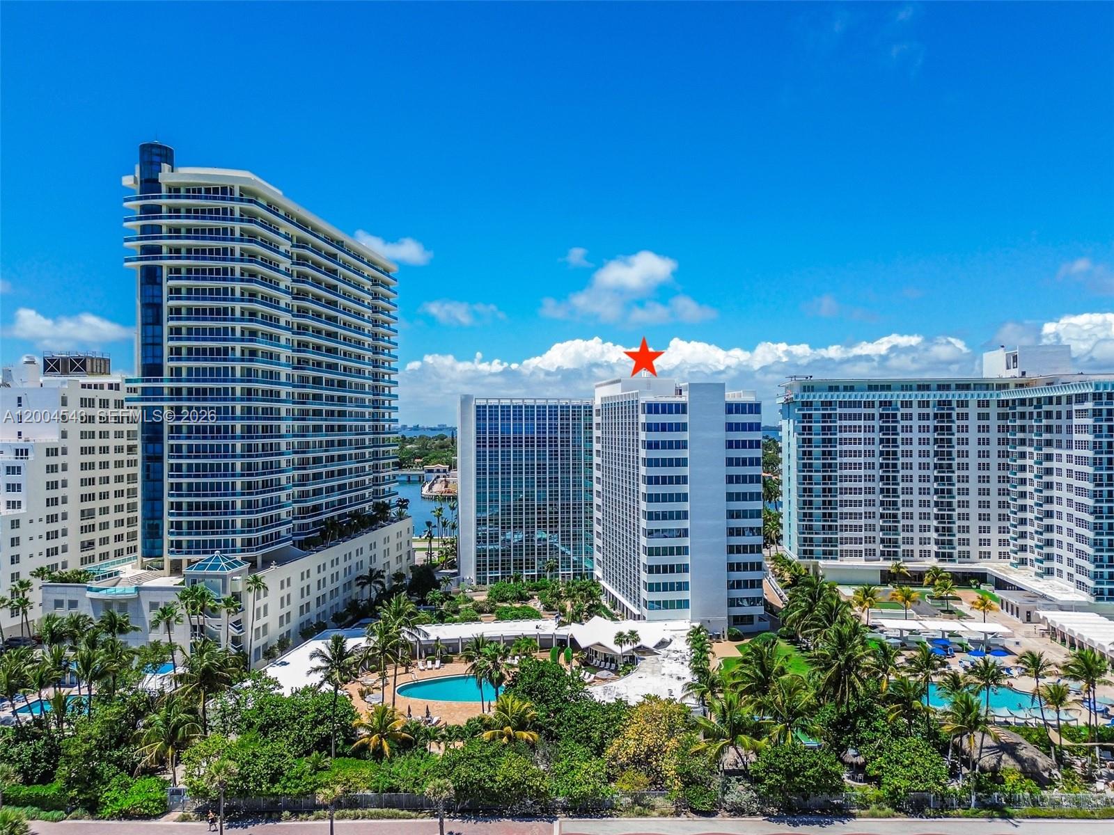 An aerial view shows multiple high-rise apartment buildings surrounded by palm trees and swimming pools — 5055 Collins Ave # 3K, Miami Beach FL 33140, MIAMI BEACH, FL