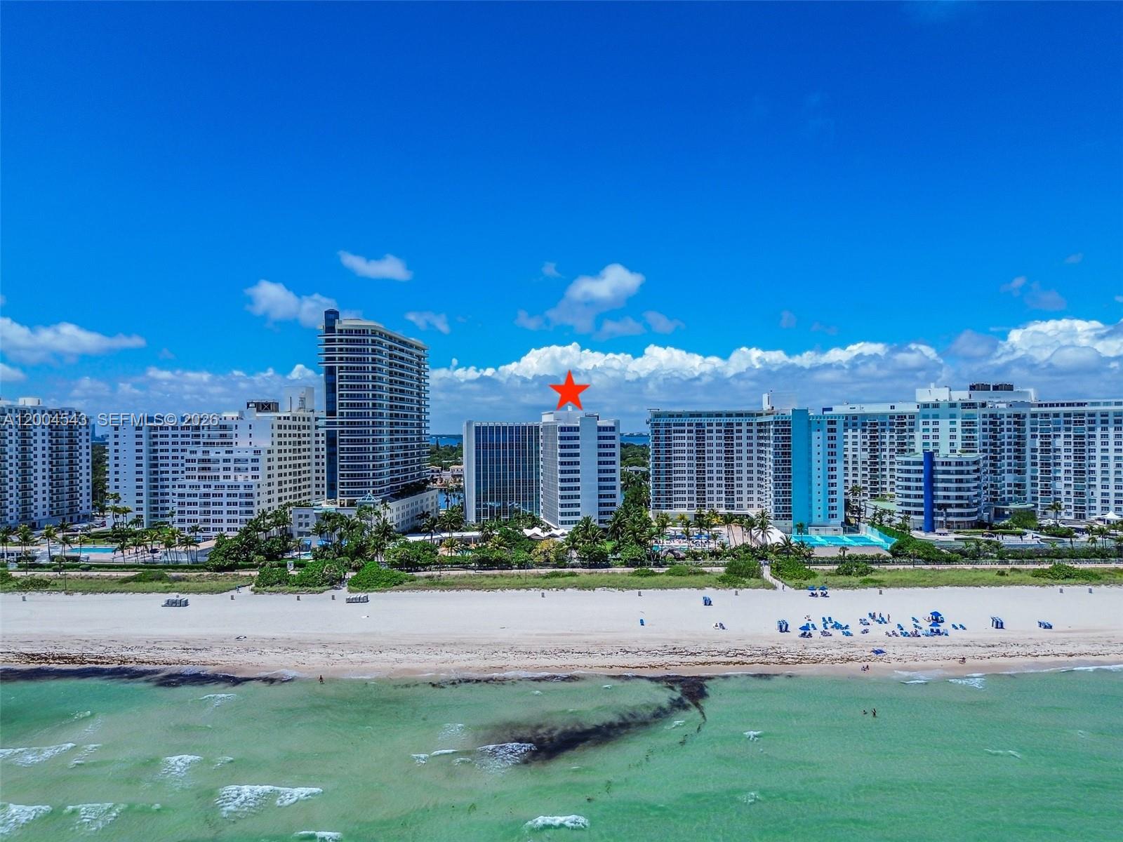 An aerial view of a beach with several high-rise apartment buildings along the coastline — 5055 Collins Ave # 3K, Miami Beach FL 33140, MIAMI BEACH, FL