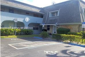 An exterior view of a two-story building with a parking lot and handicap spaces — 4271 NW 5th St # 117, Plantation FL 33317, PLANTATION, FL