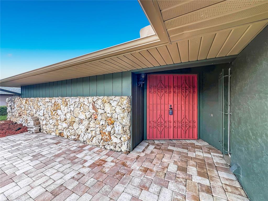 An aerial view shows a house with a gray roof, a paved patio, and pool — 6193 VALERIAN BOULEVARD, ORLANDO, FL