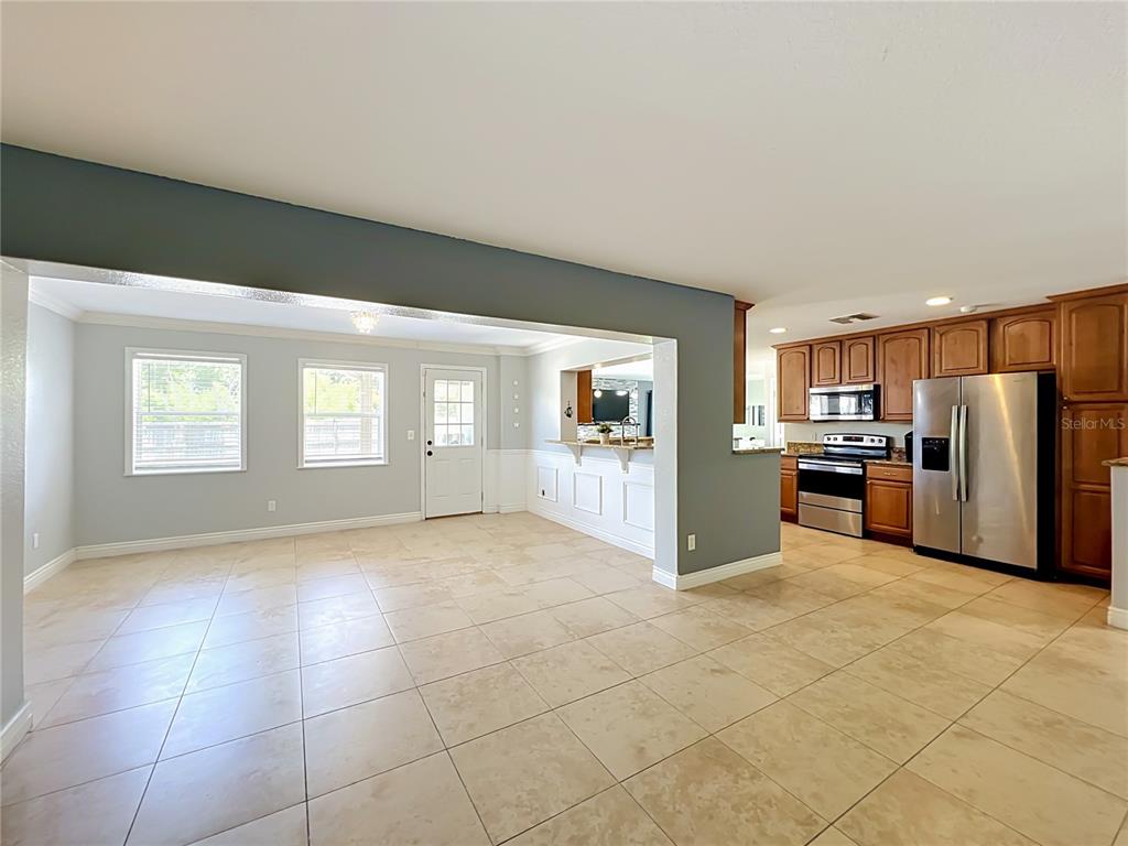 A covered patio features a paved stone floor, a dining set, and a backyard grill — 6193 VALERIAN BOULEVARD, ORLANDO, FL