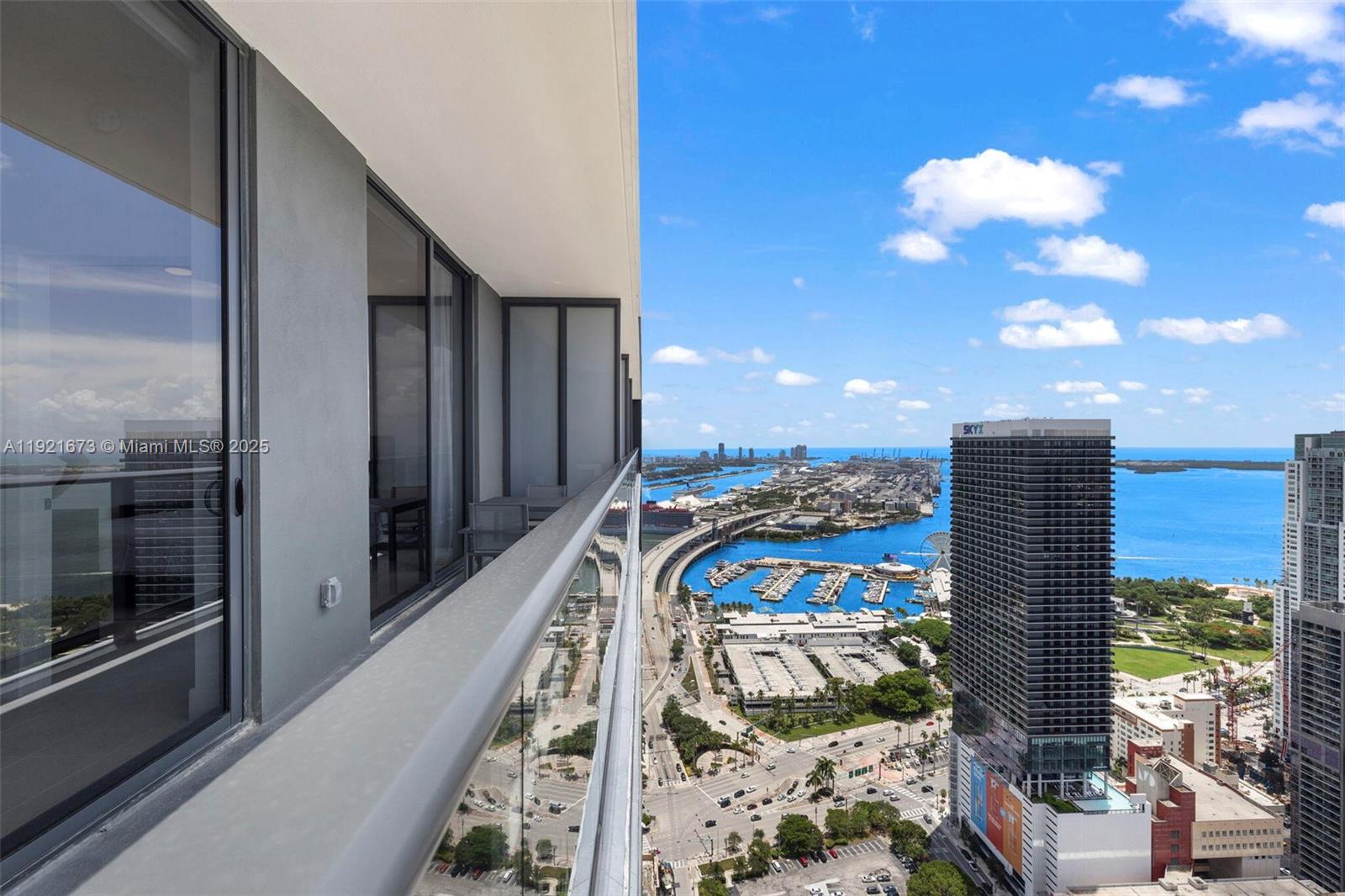 An aerial view shows a red-based high-rise building with a rooftop pool and surrounding skyscrapers — 159 NE 6th St # 5008, Miami FL 33132, MIAMI, FL