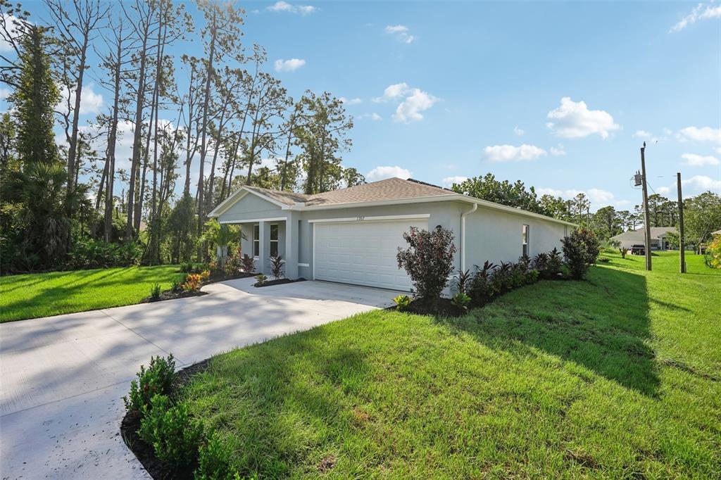 A single-story house with a gray exterior, a two-car garage, and a landscaped front yard — 196 S ROOKS AVENUE, INVERNESS, FL