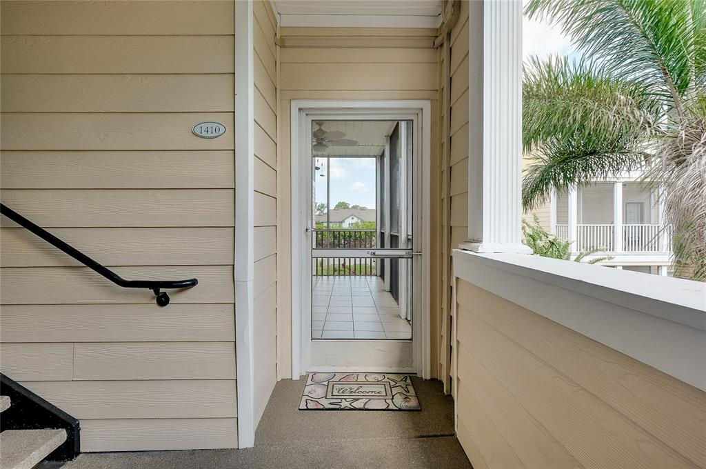 An exterior view of a building entrance with a screen door and a welcome mat — 4802 51ST STREET W UNIT 1410, BRADENTON, FL