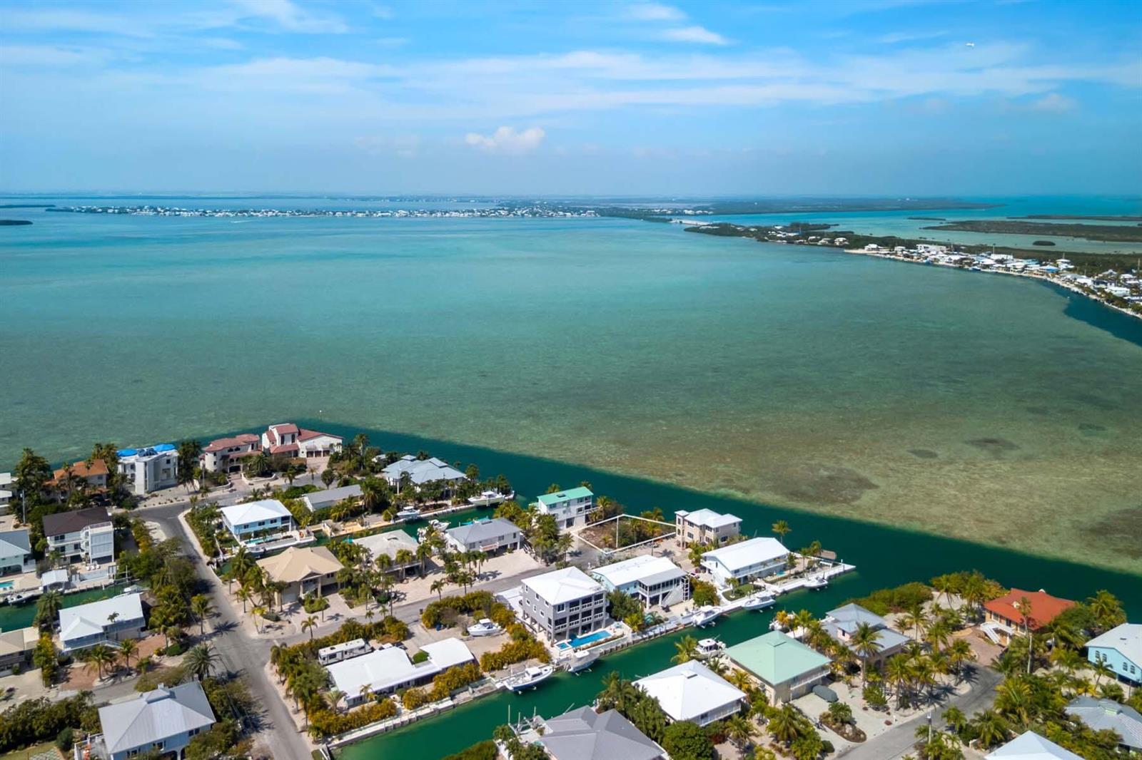 An aerial view shows waterfront homes along a canal in a tropical coastal neighborhood — 00000 Lagoon Drive, FL 33042, FL