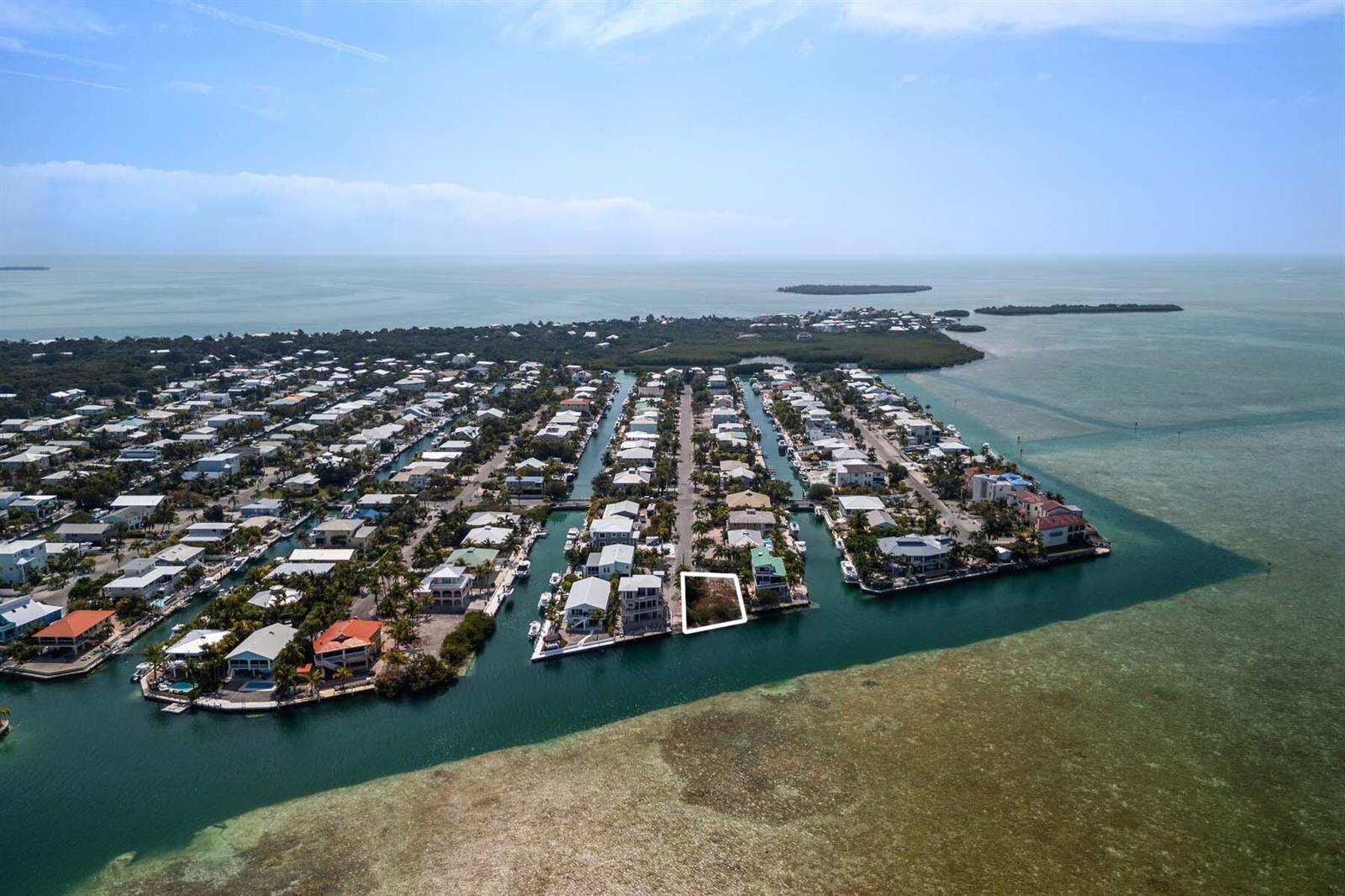 An aerial view shows a vacant waterfront lot outlined in white within a residential neighborhood — 00000 Lagoon Drive, FL 33042, FL