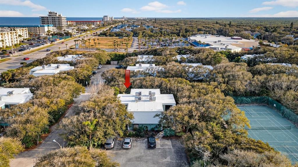 An aerial view shows a multi-unit residential building with a red arrow pointing toward it — 4150 S ATLANTIC AVENUE UNIT 114B, NEW SMYRNA BEACH, FL