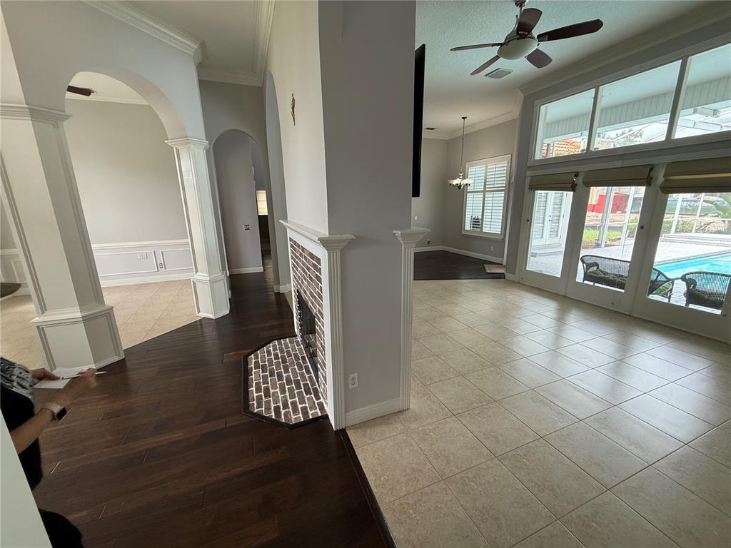 A living area features tile flooring, a brick fireplace, and a view of a pool — 325 LESLIE LANE, LAKE MARY, FL