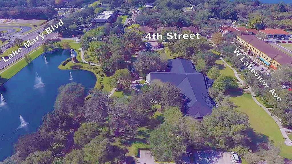 An aerial view shows a building surrounded by trees, a pond, and nearby streets — 2300 W LAKE MARY BOULEVARD, LAKE MARY, FL