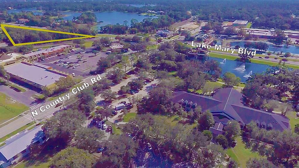 Aerial view of a triangular wooded lot located near a road and a lake — 2300 W LAKE MARY BOULEVARD, LAKE MARY, FL