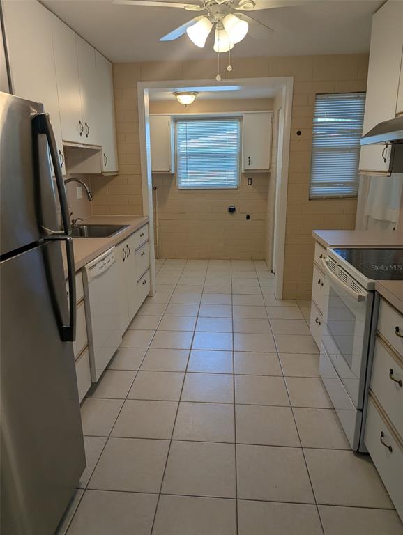 An empty room with blue walls, light wood-look flooring, a white door, and vertical blinds — 314 ROSLYN AVENUE, NEW SMYRNA BEACH, FL