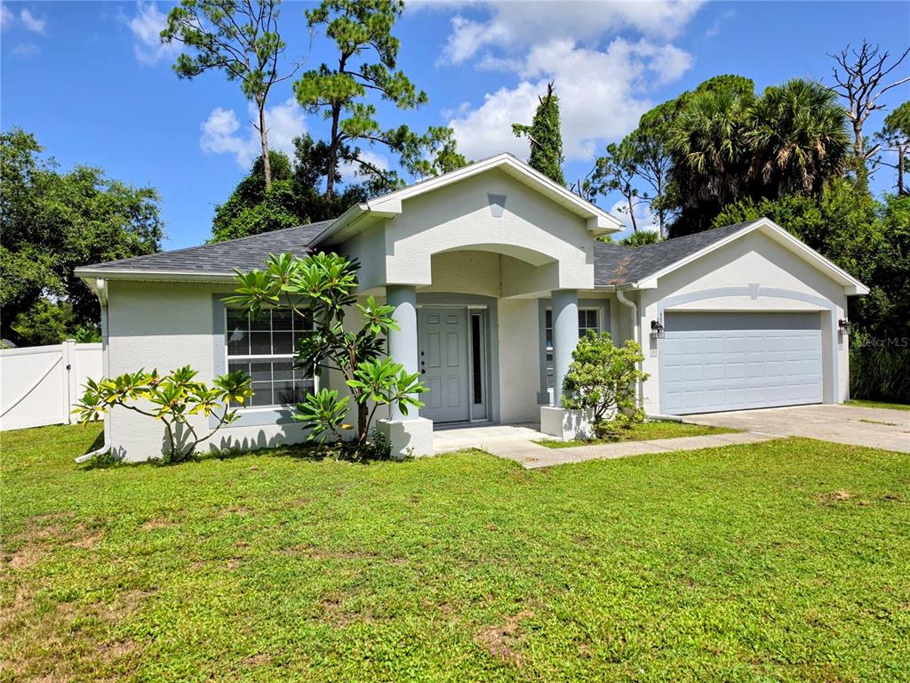 A single-story house with a light-colored exterior, a two-car garage, and a covered front entryway — 3369 JENNINGS STREET, NORTH PORT, FL