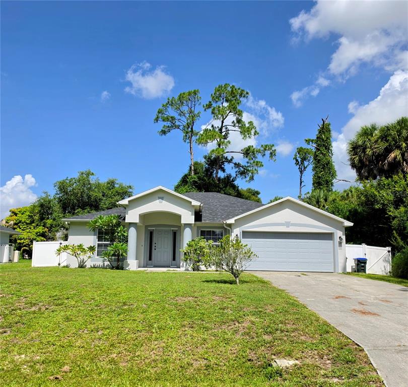A single-story house with a light-colored exterior, a two-car garage, and a front porch — 3369 JENNINGS STREET, NORTH PORT, FL