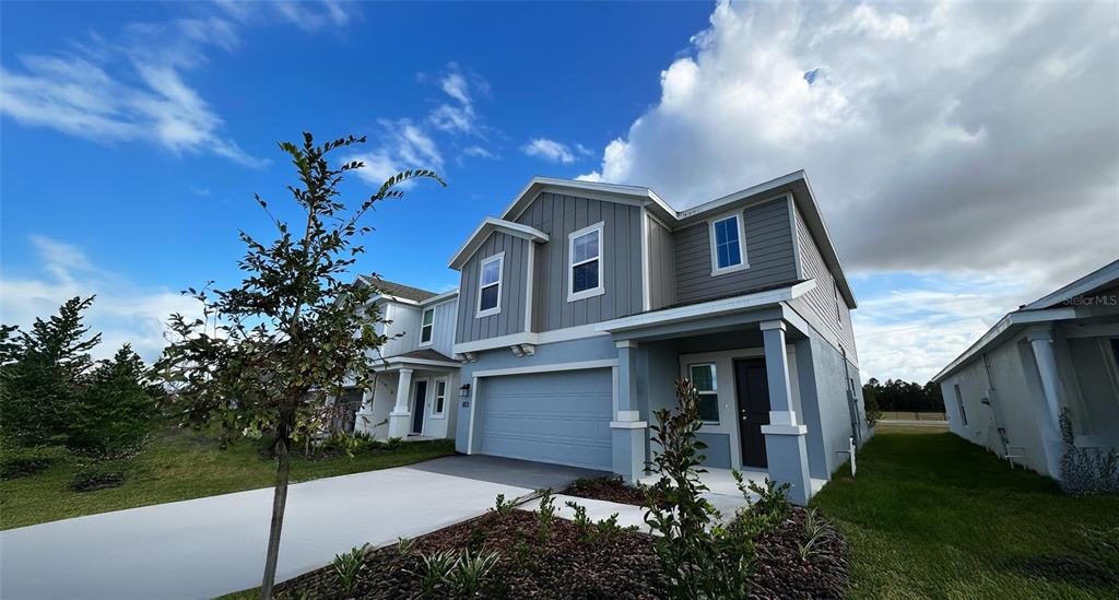 A two-story house with a gray garage, blue siding, and a concrete driveway — 1658 TEAGAN LANE, WINTER HAVEN, FL