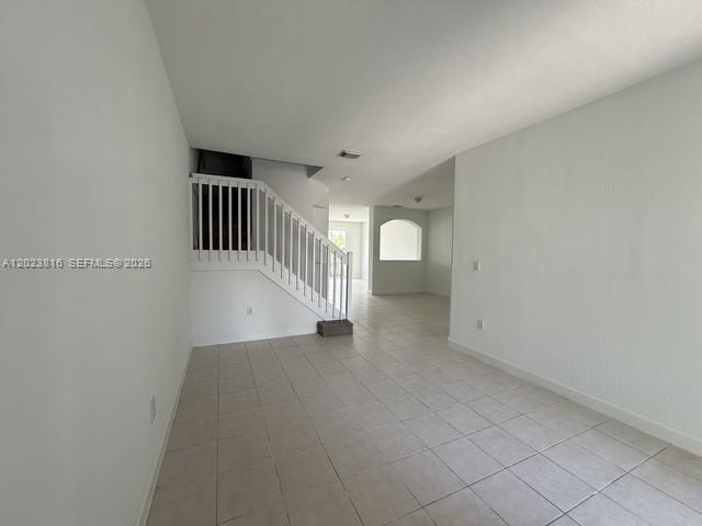 An interior view shows a tiled room with a staircase and an arched doorway — 11419 NW 76th Ter, Doral FL 33178, DORAL, FL