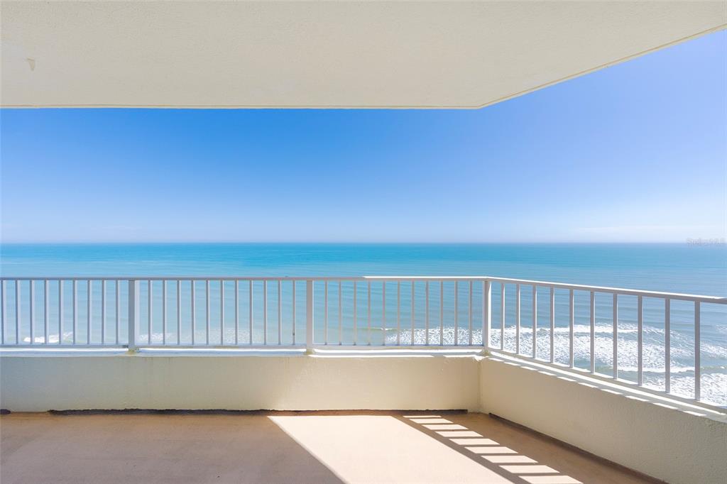 A balcony with a white metal railing overlooks the ocean under a clear blue sky — 2937 S ATLANTIC AVENUE UNIT 1606, DAYTONA BEACH SHORES, FL