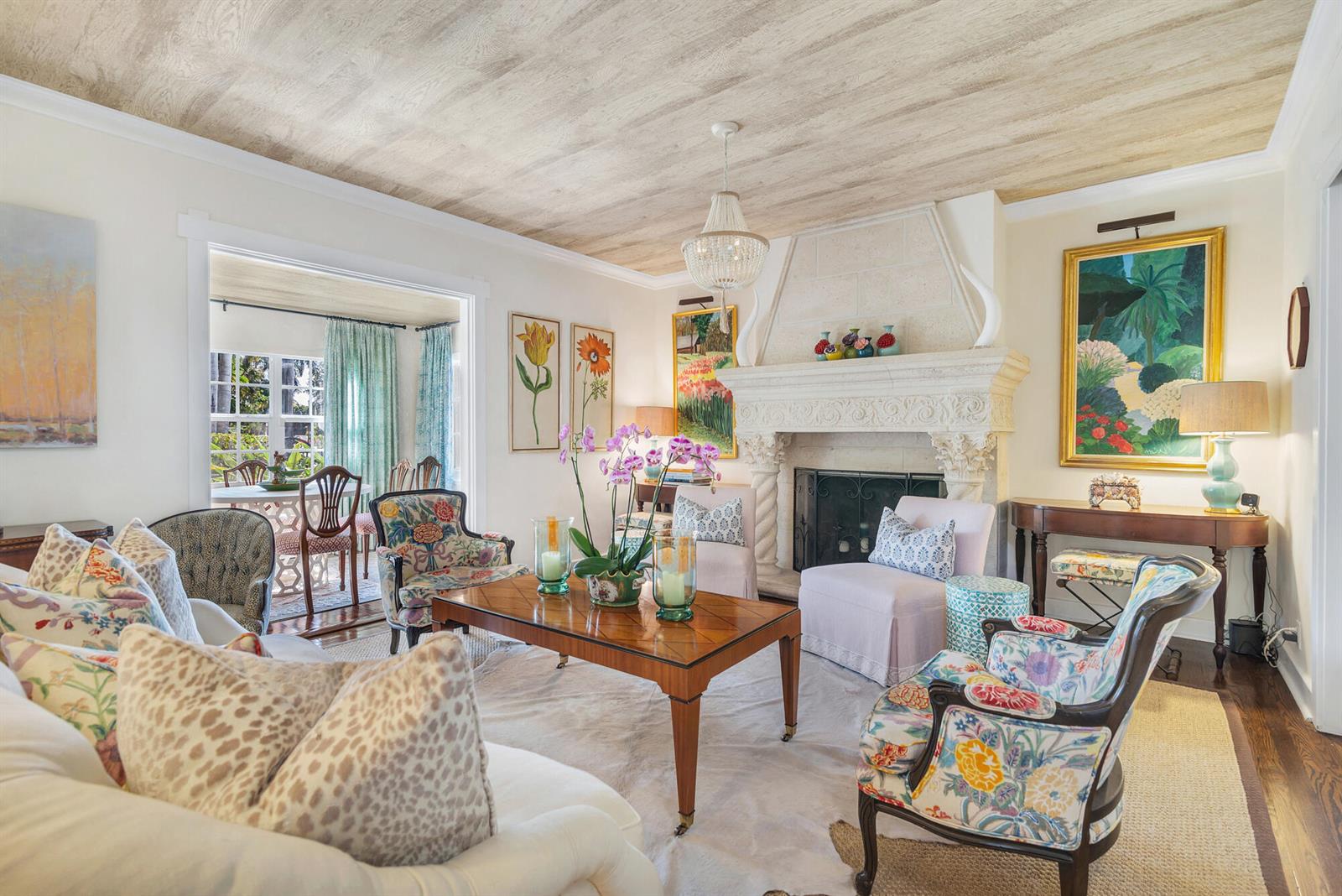 A living room features a stone fireplace, patterned armchairs, a wooden coffee table, and wood-paneled ceiling — 3213 Vincent Road, West Palm Beach FL 33405, WEST PALM BEACH, FL