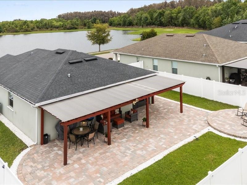 An aerial view shows a house with a covered patio, brick pavers, and a lake view — 2962 HARLOW AVENUE, ST CLOUD, FL