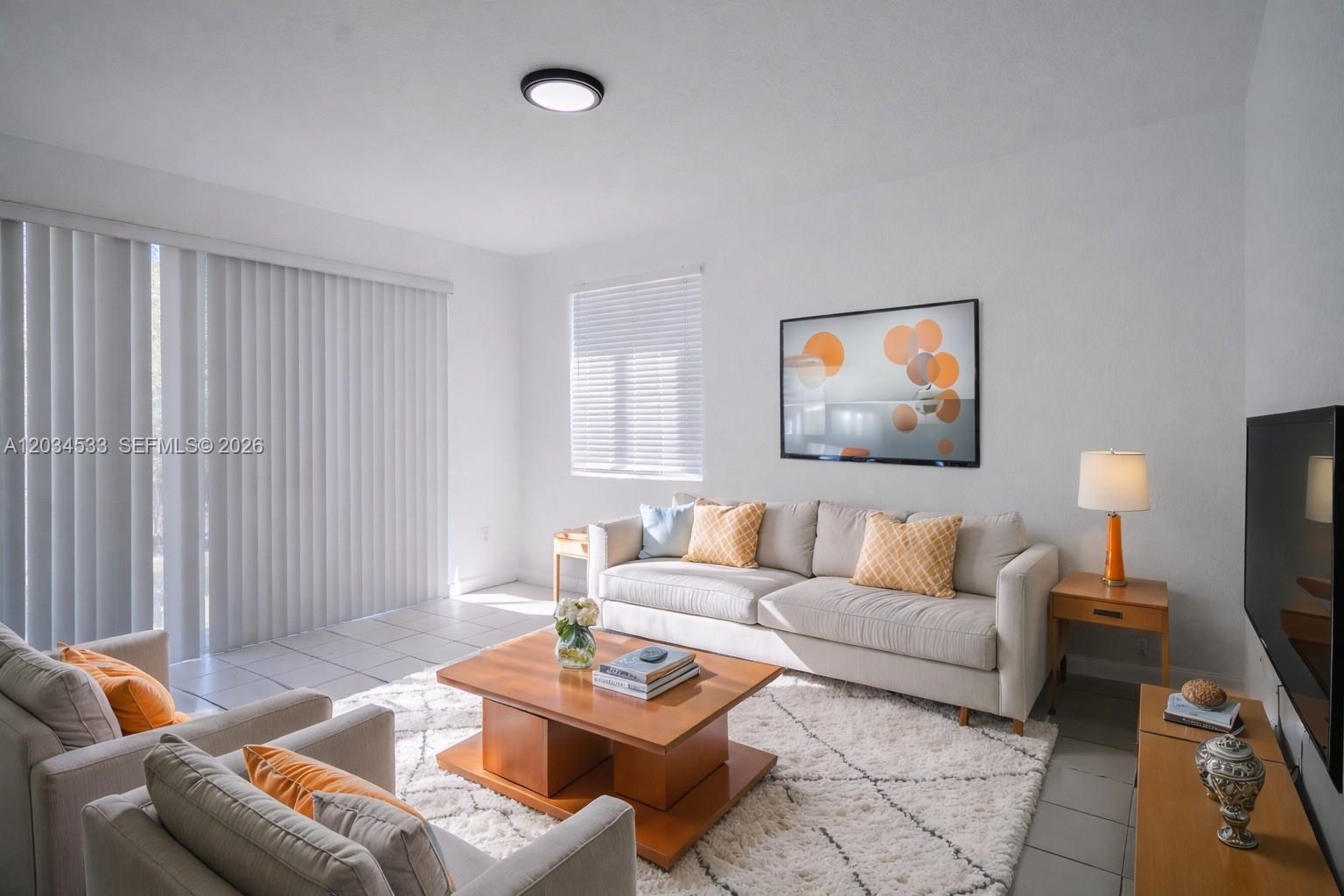 A living room features a beige sofa, two armchairs, a wooden coffee table, and tile flooring — 1441 SE 24th Ct # 257, Homestead FL 33035, HOMESTEAD, FL