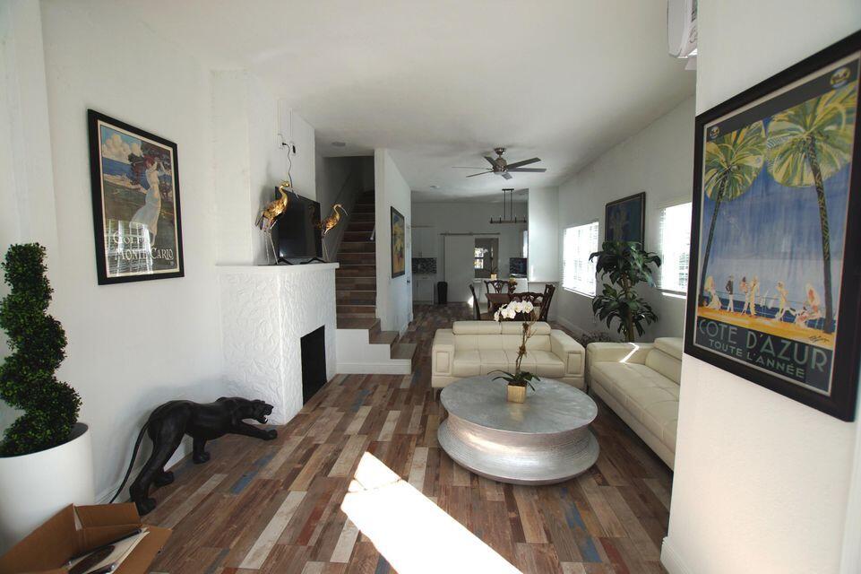 A living room features white sofas, a round coffee table, and a fireplace with stairs — 331 NW 1st Avenue, Boynton Beach FL 33435, BOYNTON BEACH, FL