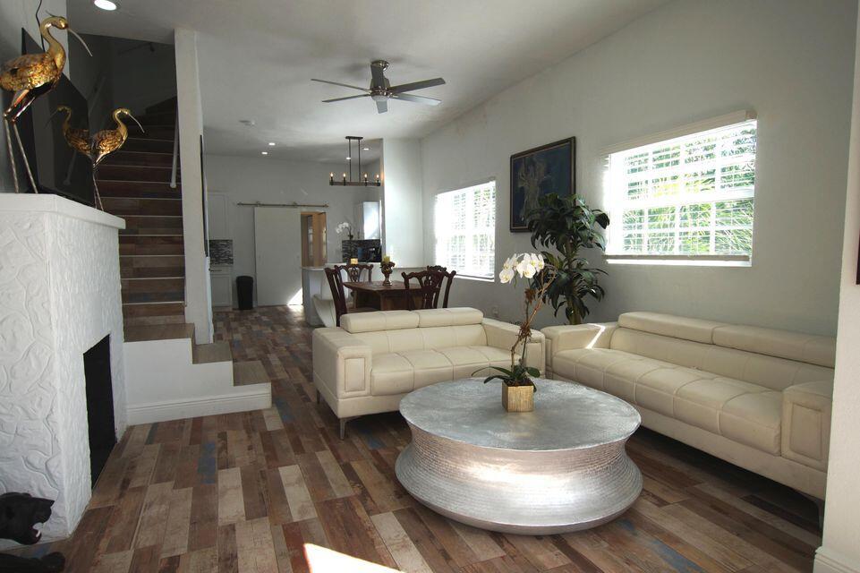 A living room features white leather sofas, a silver coffee table, and wood-look tile flooring — 331 NW 1st Avenue, Boynton Beach FL 33435, BOYNTON BEACH, FL