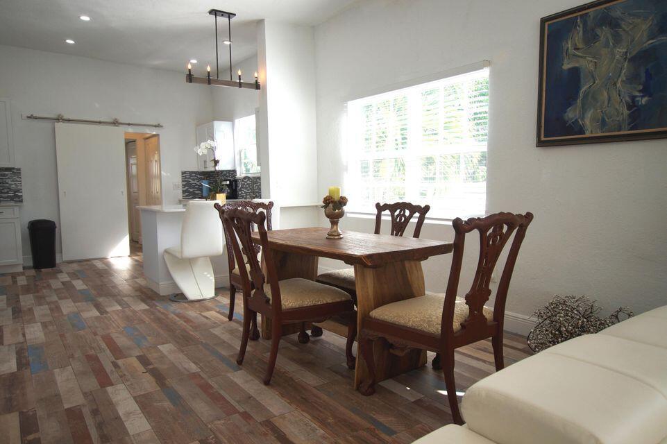 A dining area with a wooden table, four chairs, and wood-look tile flooring — 331 NW 1st Avenue, Boynton Beach FL 33435, BOYNTON BEACH, FL