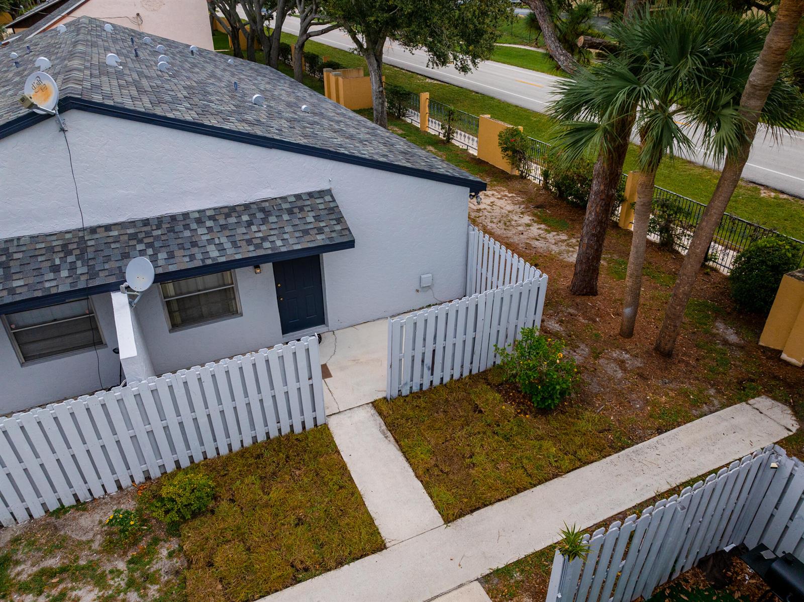 An aerial view shows a gray house with a fenced patio and a concrete walkway — 2007 Oleander Boulevard Apt D, Fort Pierce FL 34950, FORT PIERCE, FL