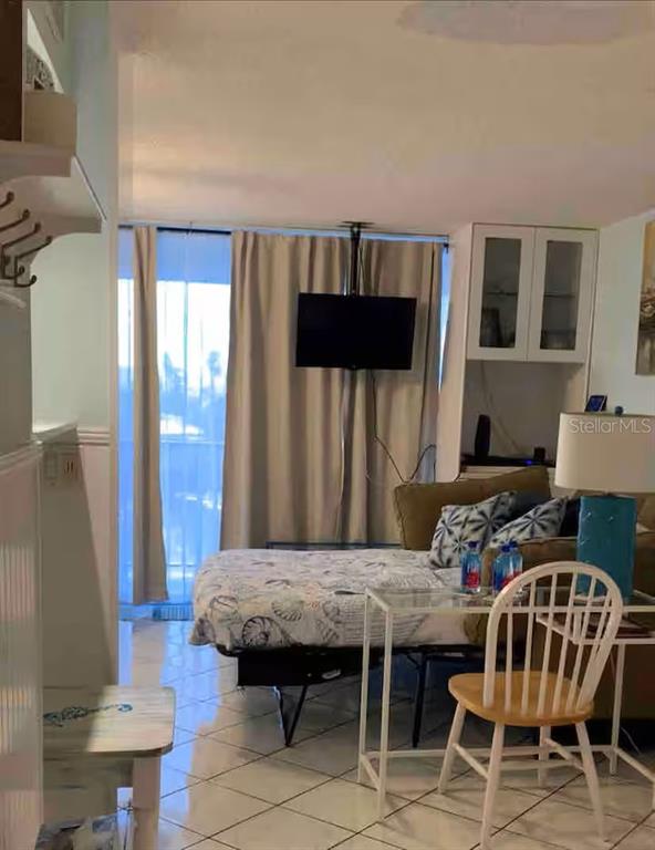 A room features a bed, a television mounted on the wall, and a small dining table — 800 BAYWAY BOULEVARD UNIT 26, CLEARWATER BEACH, FL