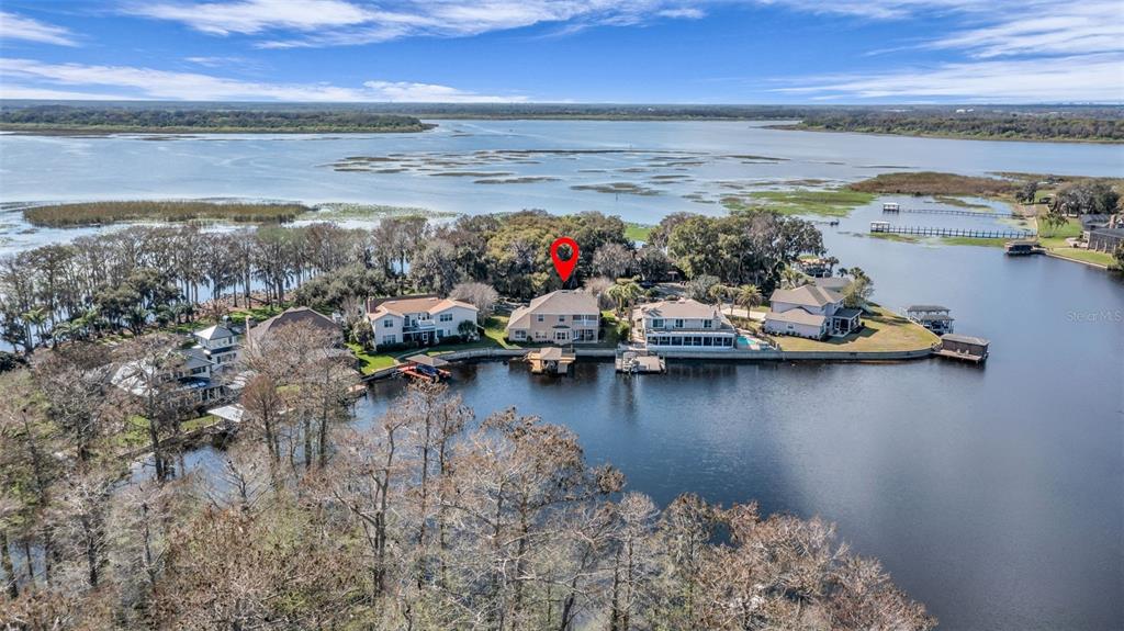 An aerial view shows several waterfront houses on a peninsula extending into a large lake — 1425 RIVIERA DRIVE, KISSIMMEE, FL