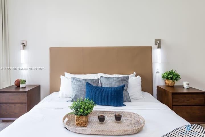 A bedroom features a tan headboard, two wooden nightstands, and a tray with two drinks — 777 N Ocean Dr # S228, Hollywood FL 33019, HOLLYWOOD, FL