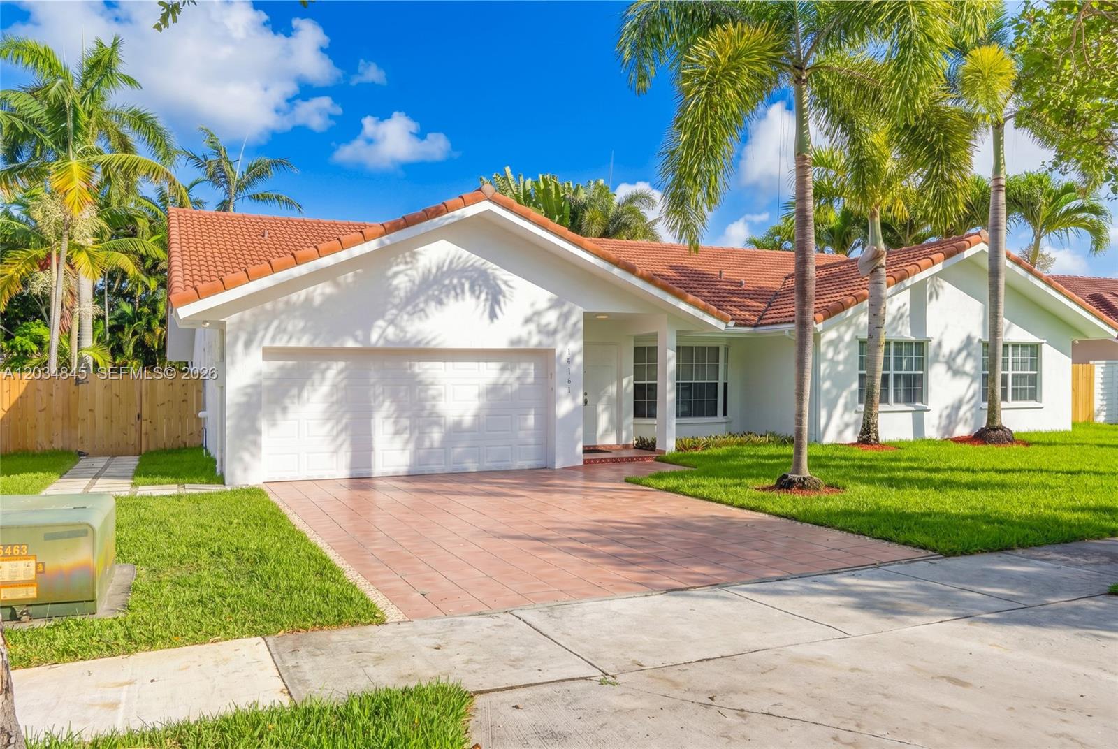 A single-story house with a white exterior, tiled roof, and a paved driveway — 14161 SW 153rd Ave, Miami FL 33196, MIAMI, FL