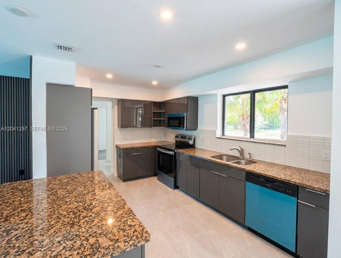 A kitchen features gray cabinets, granite countertops, a blue dishwasher, and a large island — 19700 NE 11th Pl, Miami FL 33179, MIAMI, FL