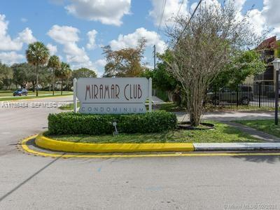 A sign for the Miramar Club Condominium stands in a landscaped area near a road — 3400 Foxcroft Rd # 212, Miramar FL 33025, MIRAMAR, FL