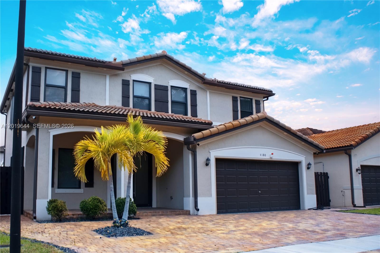 A two-story house with a tiled roof, a paved driveway, and a palm tree — 4180 NE 21st St, Homestead FL 33033, HOMESTEAD, FL