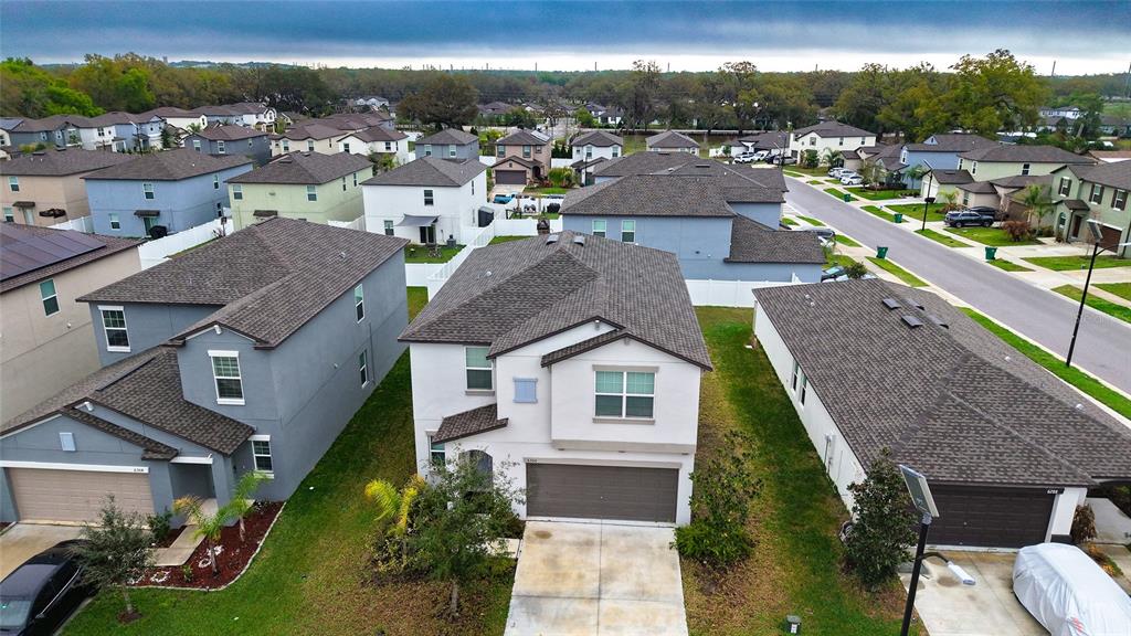 An aerial view shows a suburban neighborhood with several two-story houses and paved streets — 6300 BEVERLY HILLS DRIVE, ZEPHYRHILLS, FL