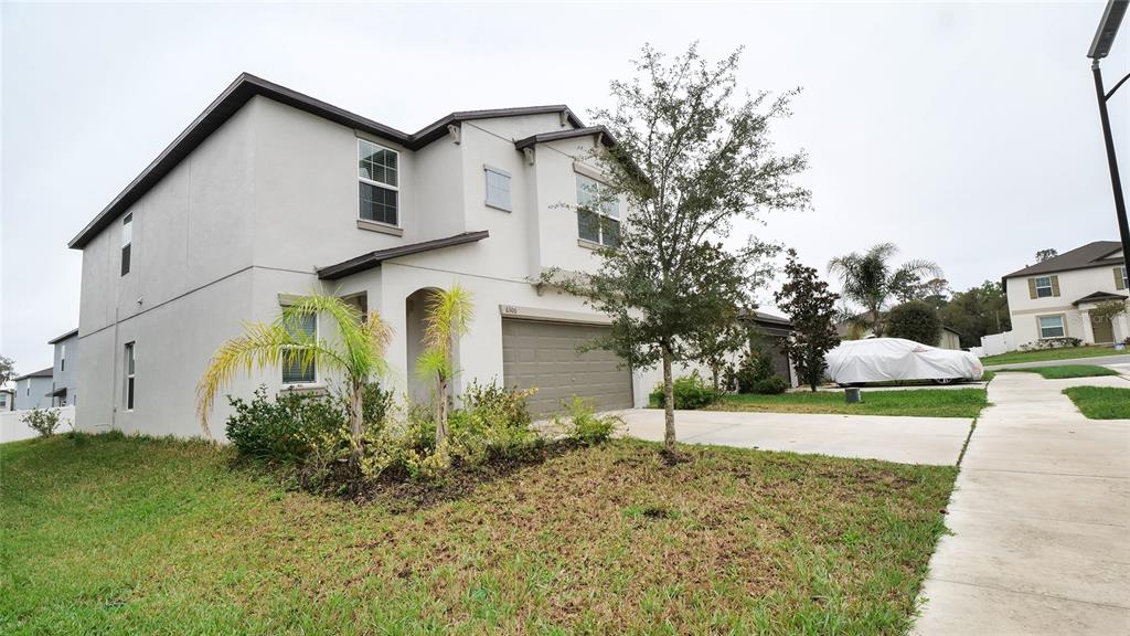 A two-story suburban house with a light-colored stucco exterior and a two-car garage — 6300 BEVERLY HILLS DRIVE, ZEPHYRHILLS, FL