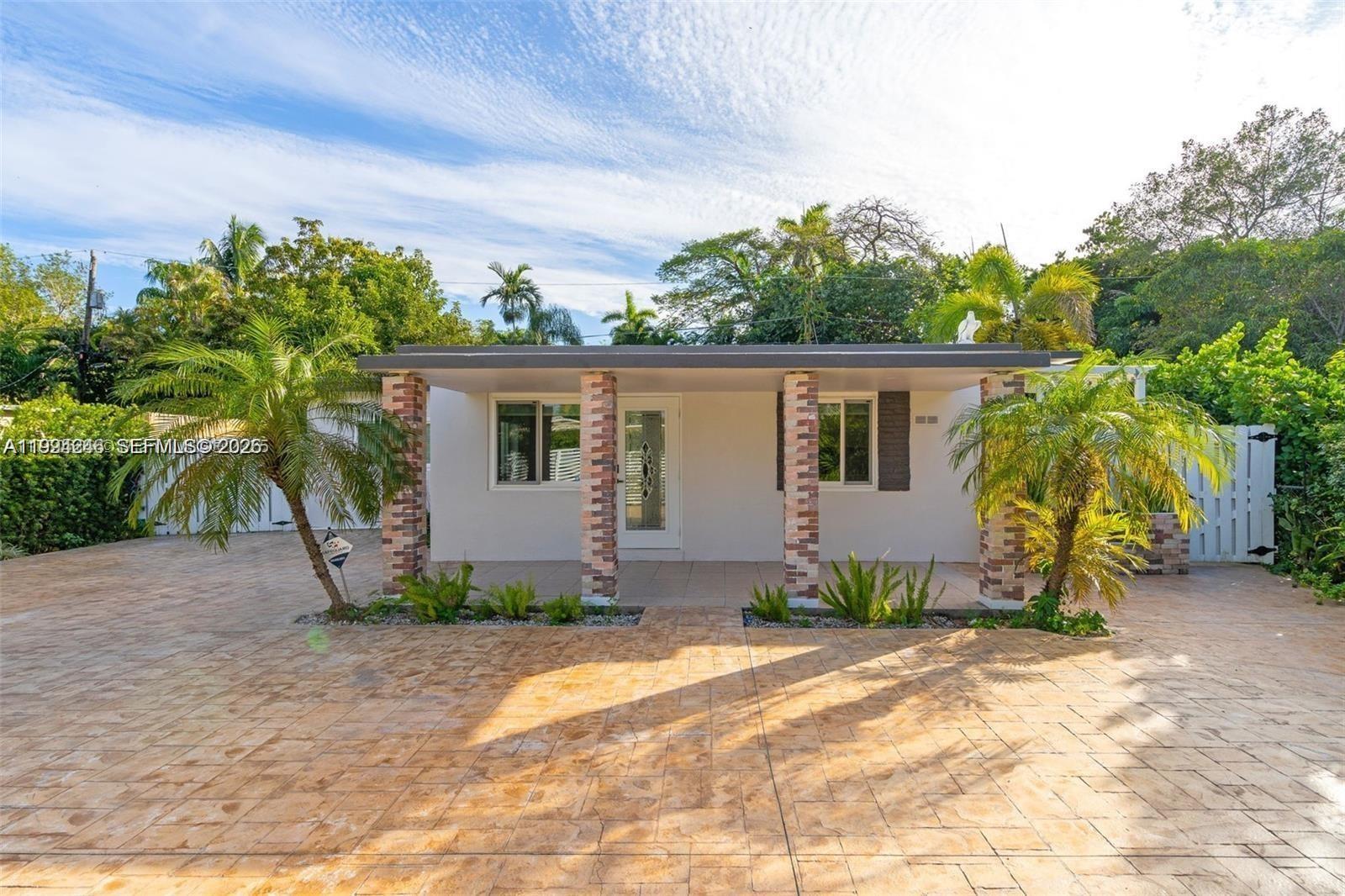 A single-story house features a covered front porch with brick columns and a paved driveway — 3800 Charles Ter, Miami FL 33133, MIAMI, FL