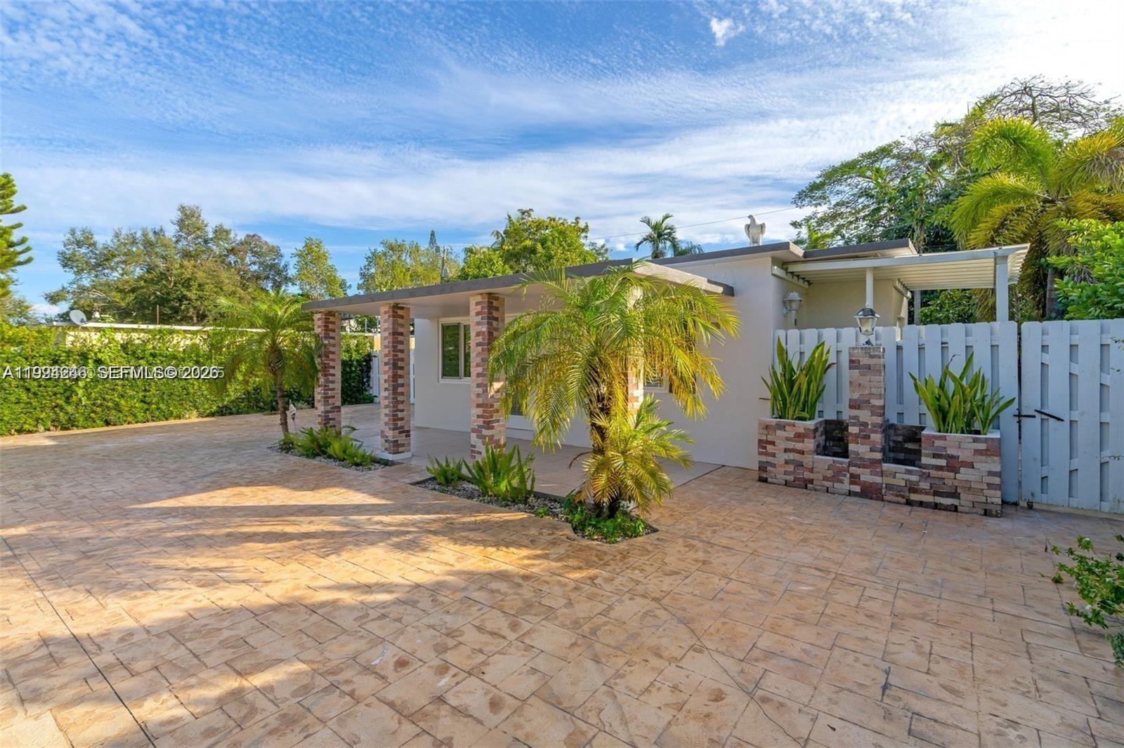 A single-story house features a brick-columned porch, paved driveway, and decorative brick planters — 3800 Charles Ter, Miami FL 33133, MIAMI, FL