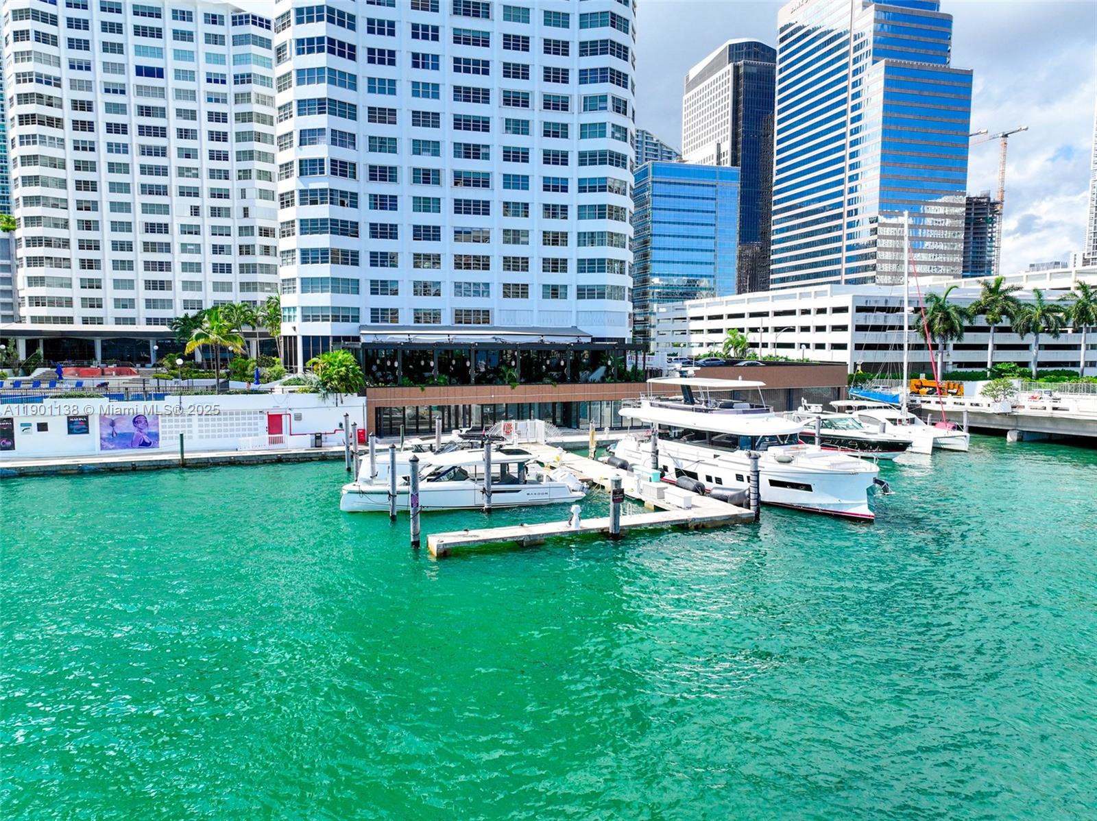 A view of a marina with docked yachts in front of tall city buildings — 801 Brickell Bay Dr, Miami FL 33131, MIAMI, FL